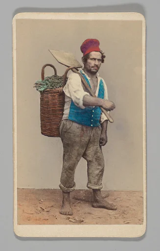 [Studio Portrait: Man Carrying Shovel and Basket of Rags]
