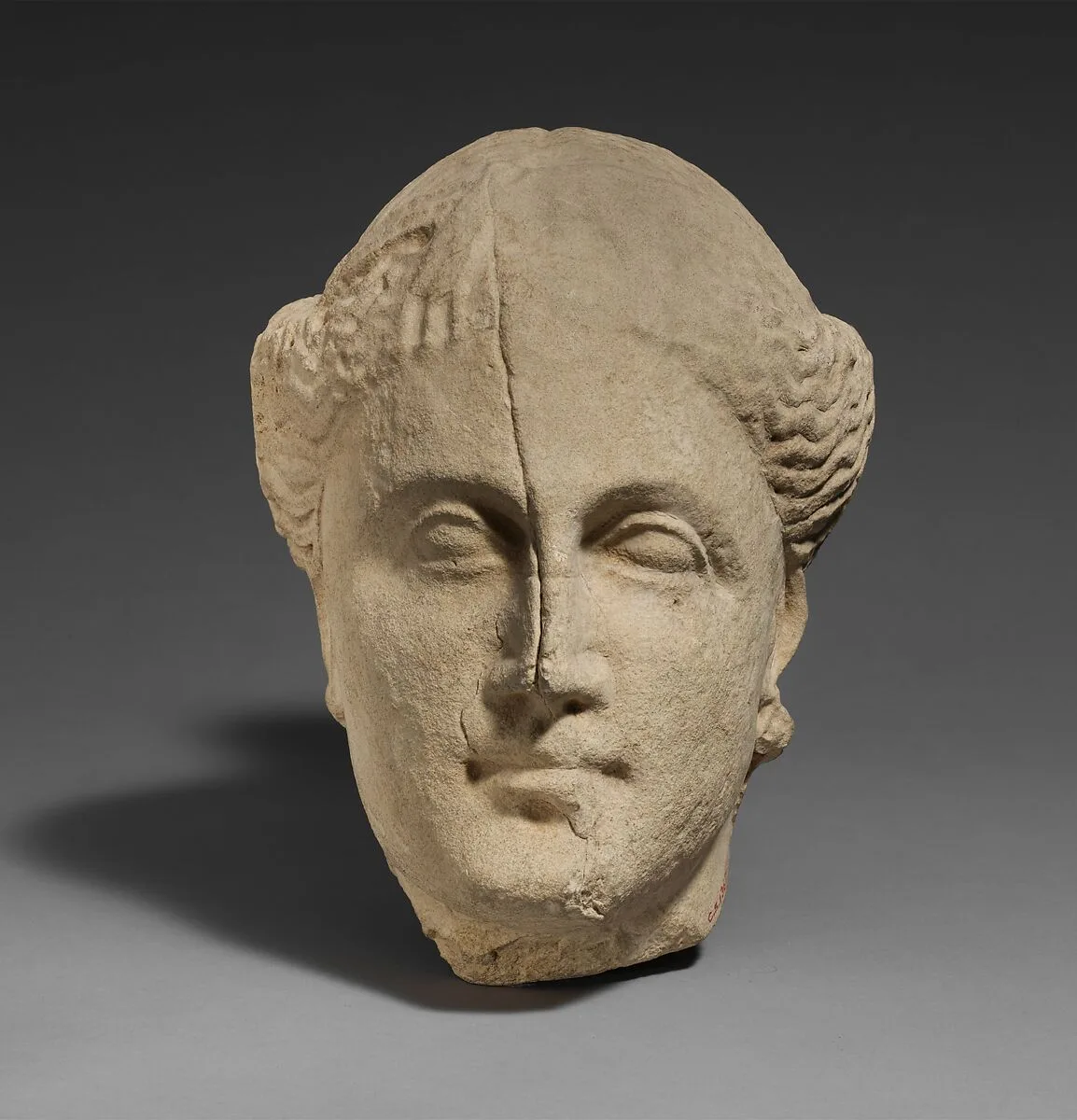 Limestone head of a female votary — Unknown