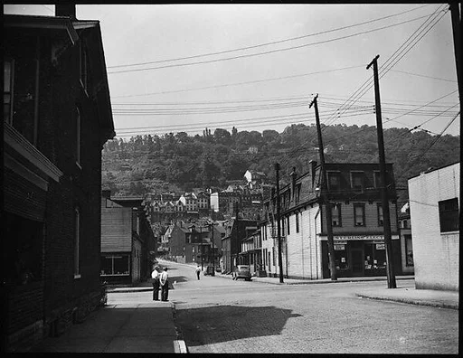 [Street Scene with Houses on Hillside in Distance]