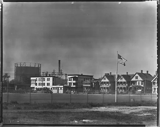 [Houses and Oil Refinery Across Baseball Field with Flag in Foreground, Bridgeport, Connecticut]