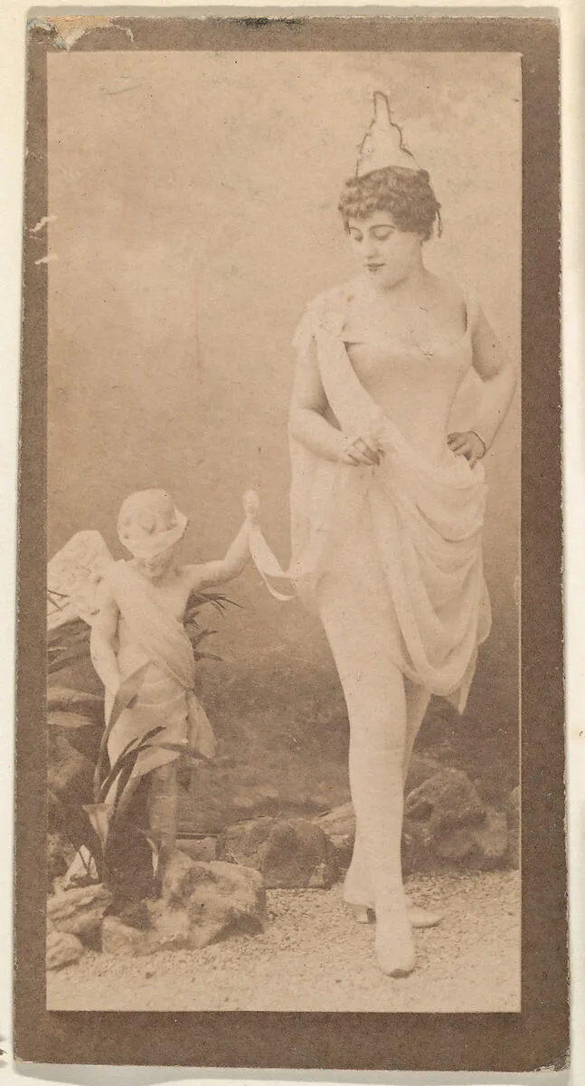 Actress posing with statue of cherub, from the Actresses series (N668) — Unknown