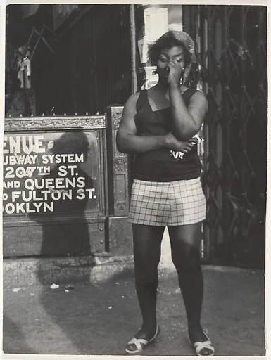 [Woman Wearing Headscarf, Tee Shirt, and Shorts, on Street at Subway Entrance, New York City]
