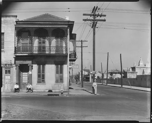 [Greek Revival Town House on Street Corner with Men Seated in Doorway, New Orleans, Louisiana]