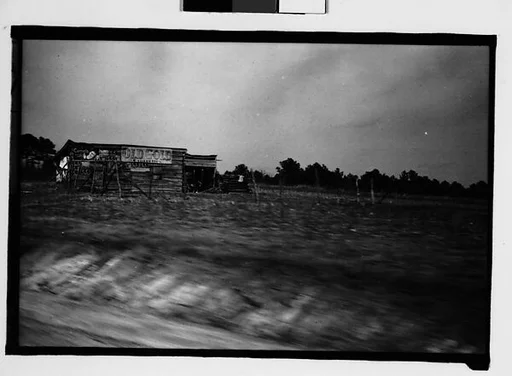 [Roadside Barn with Advertisements on Façade, From Moving Automobile, Macon, Georgia]