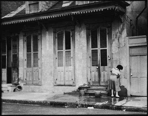 [Woman Outside Shuttered House, New Orleans, Louisiana]