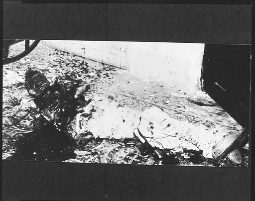 [Copy of Newspaper File Photograph: Decomposing Corpse in Blood-Spattered Courtyard, Probably Havana]