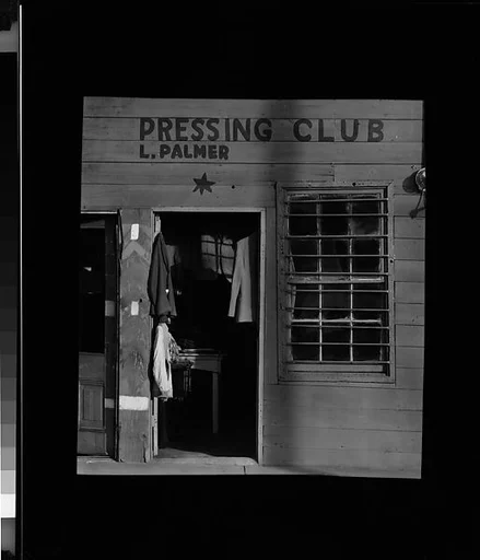 [Star Pressing Club Laundry with Hanging Clothes in Doorway, Vicksburg, Mississippi]