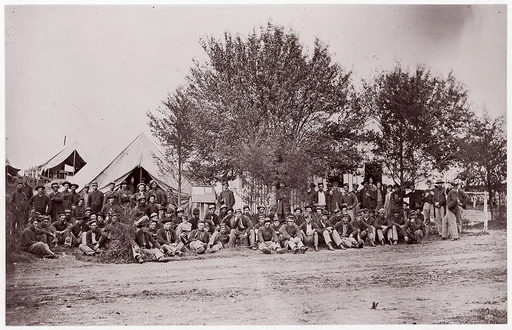 [Unidentified Company of Soldiers at Ease, Seated on Ground in Tented Camp]
