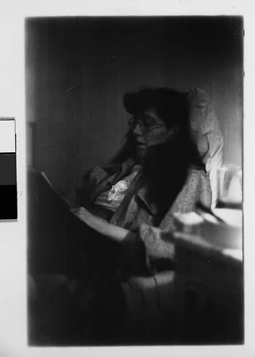 [Two 35mm Film Frames: Jane Smith Evans Reading Newspaper in Bed, New York City]