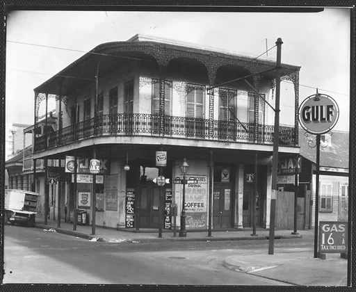 [Cast-Iron Balconied House with Ground Floor Advertisements and Gulf Filling Station Sign in Foreground, New Orleans, Louisiana]