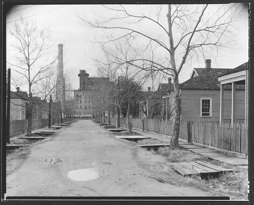 [View Down Street of Workers' Houses Leading to Factory Building]