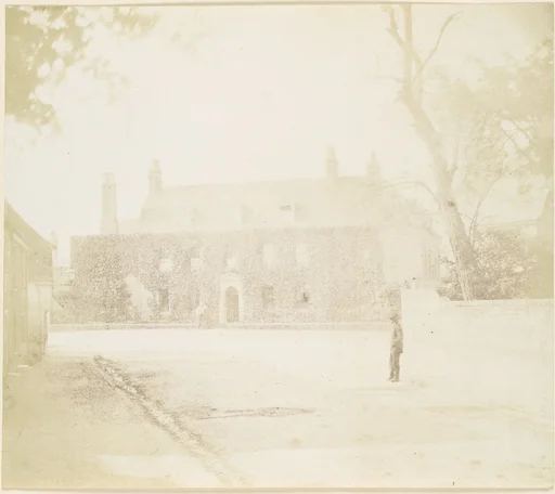 [Man in Courtyard Before House]