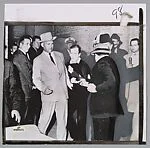 FATAL BULLET HITS OSWALD. Jack Ruby fires bullet point blank into the body of Lee Harvey Oswald at Dallas Police Station. Oswald grimaces in agony,