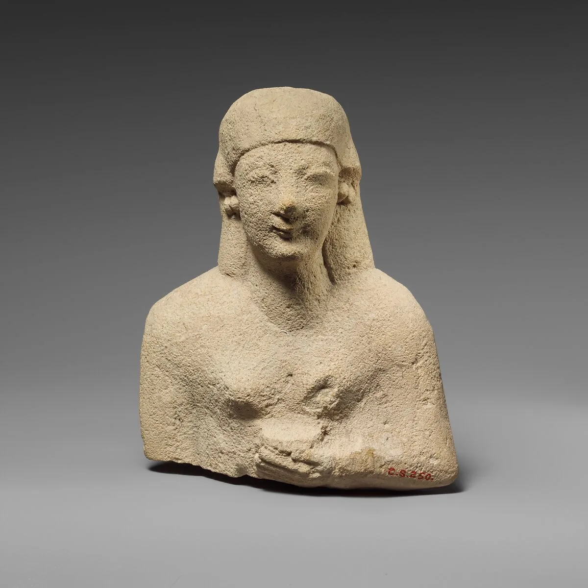 Upper part of a limestone female votary holding a vase — Unknown