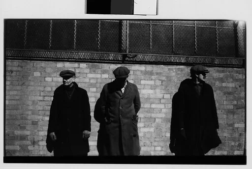 [Men in Hats and Overcoats Standing Against Brick Wall, New York City]