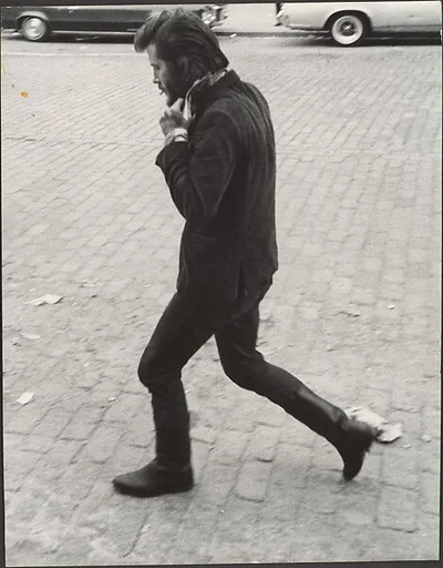 [Street Scene: Man in Boots Walking and Adjusting His Collar, New York City]