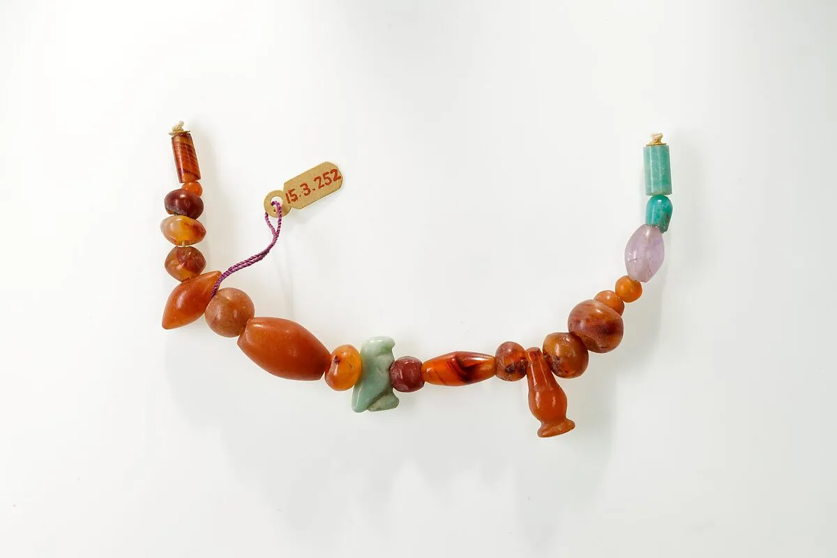 String of beads, hawk amulet and cornflower pendant — Unknown