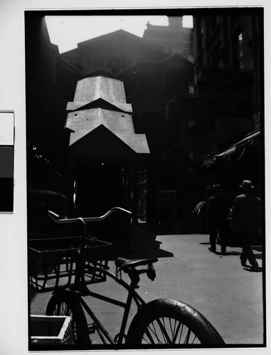 [Street Scene in Front of Elevated Train Entrance with Bicycle in Foreground, New York City]