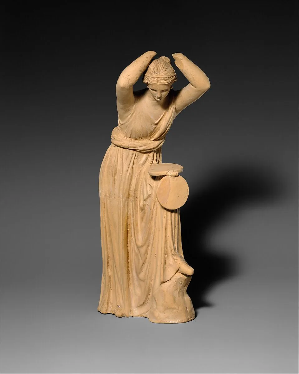 Terracotta statuette of a woman looking into a box mirror — Unknown