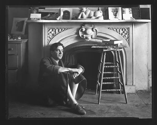 [Reuben Nakian Seated in Front of Fireplace Mantle]