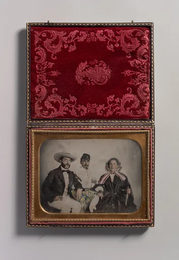[Two Men, One in Military Garb, and a Woman, Seated Around a Table]