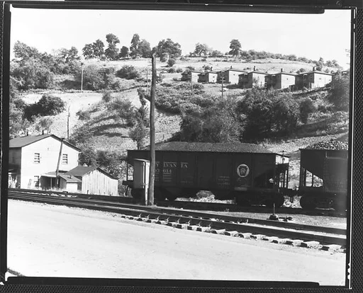 [Pennsylvania Railroad Cars Carrying Coal on Tracks below Workers' Houses in Mining Camp, Osage, West Virginia]