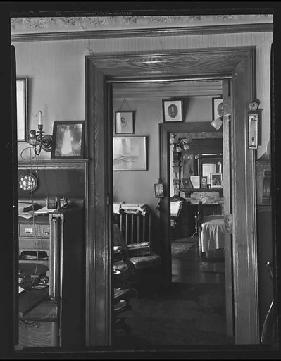 [View of Domestic Interior Showing Family Photographs Around Doorways and on Fireplace Mantle]