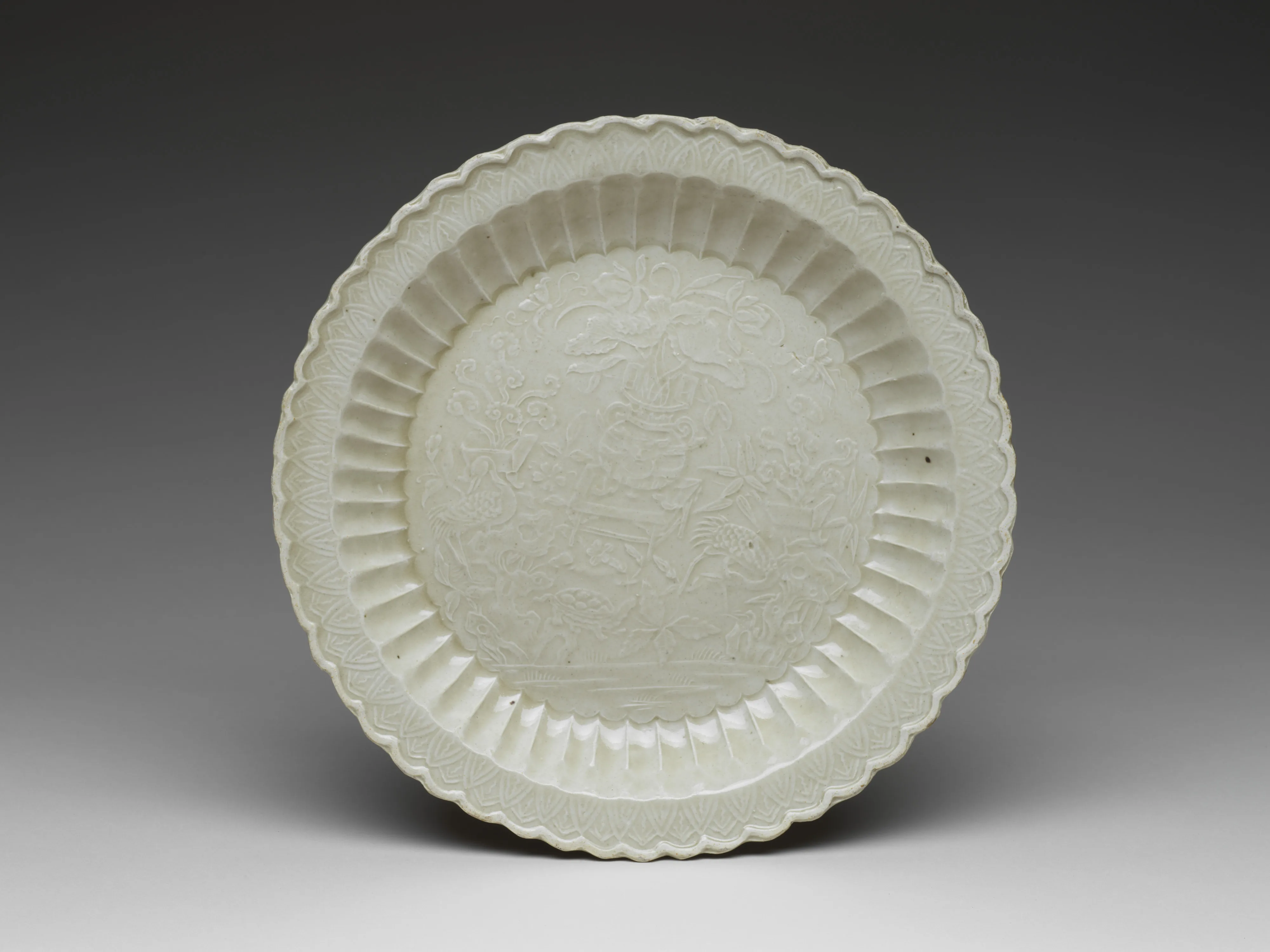 金 定窯白瓷龜鶴長春菊瓣盤|Chrysanthemum-petal dish with tortoise, cranes, and flowers — Unknown