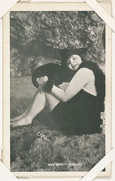 Bathing beauty seated in costume with fur from Mack Sennett Comedies Arcade series (W423) — Unknown