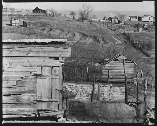[Wooden Houses with Farm Buildings and Houses on Hillside in Distance, Outskirts of Tupelo, Mississippi]
