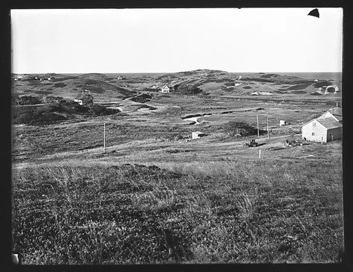 [View of Cape Cod with Junked Automobile and Houses in Distance, Massachusetts]