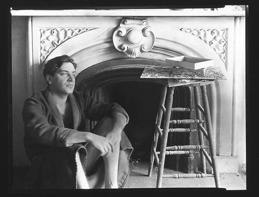 [Reuben Nakian Seated in Front of Fireplace Mantle]