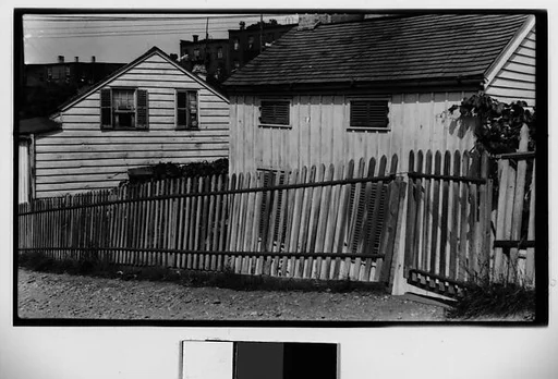[Wooden Houses Behind Picket Fence]