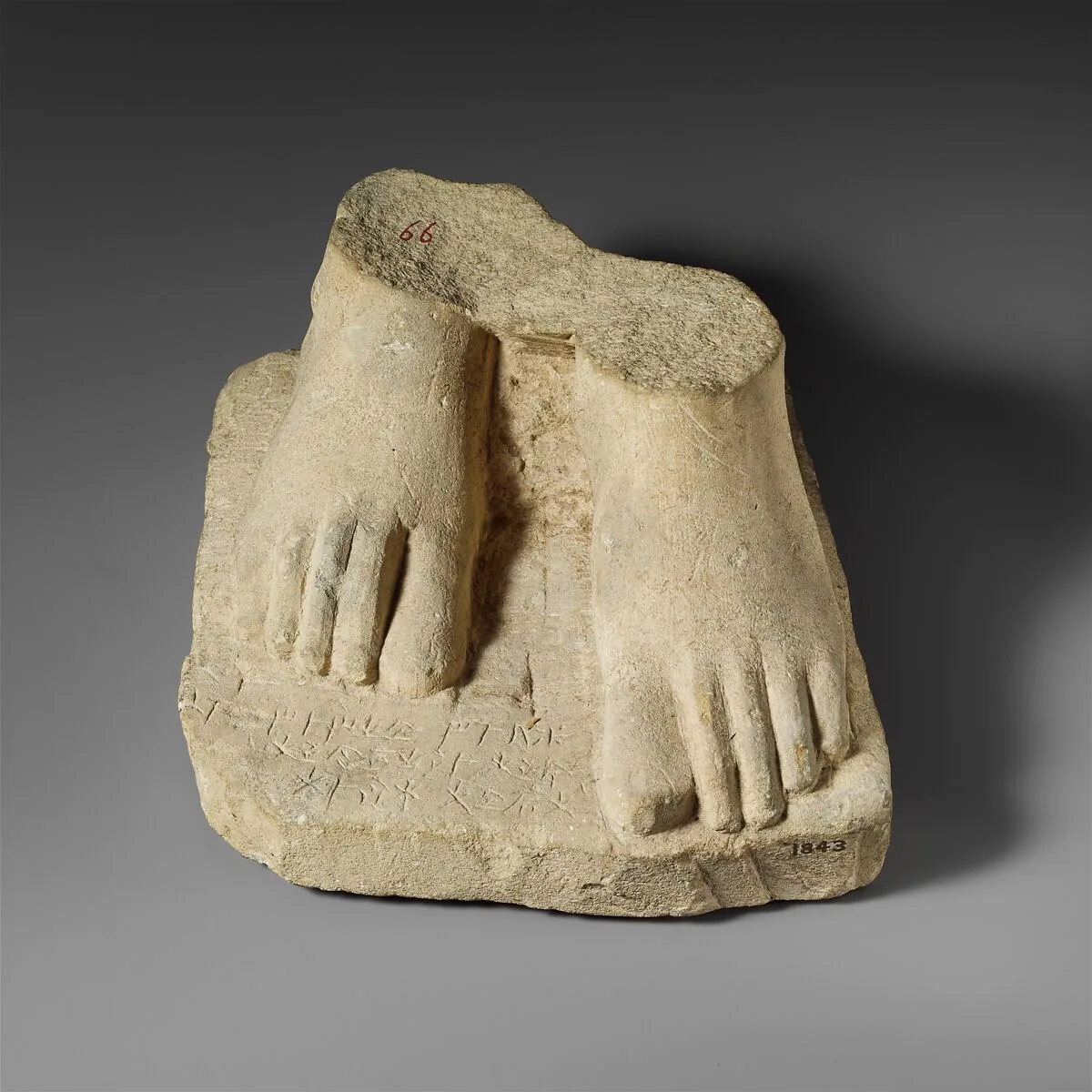 Limestone plinth with the feet of a male statuette — Unknown