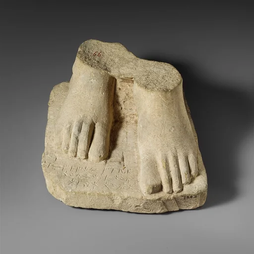Limestone plinth with the feet of a male statuette