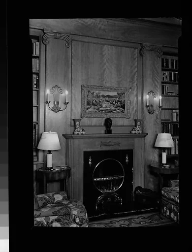 [Library Interior Showing Fireplace with Adjacent Bookshelfs and Armchairs]