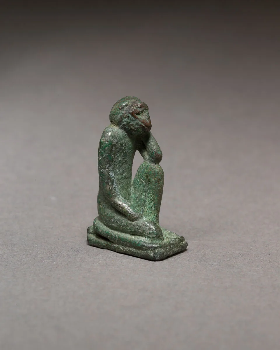 Monkey kneeling and resting its head in a hand — Unknown