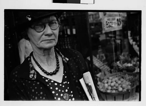 [Two 35mm Film Frames: Old Woman Outside Main Street Grocery Store, Ossining, New York]
