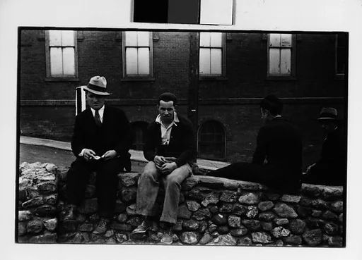 [Two 35mm Film Frames: Men Seated on Stone Wall]