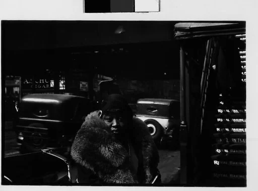 [Three 35mm Film Frames: Woman in Fur Collar Next to Elevated Train Steps, Sixth Avenue at Forty-Second Street, New York City;  Partial View of Passing Bus in Front of High-Rise Building, New York City; Outdoor Shop Display of Mushrooms and Leeks in Baskets, New York City]