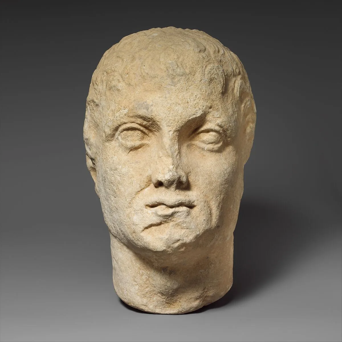 Limestone head of a beardless male votary — Unknown