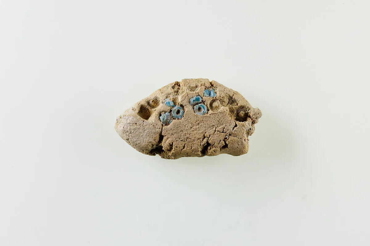 Fragment of clay lump with imbedded ring beads — Unknown