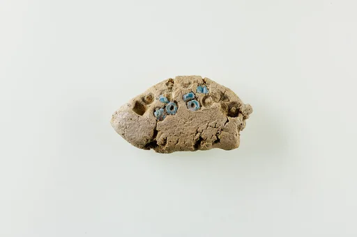 Fragment of clay lump with imbedded ring beads