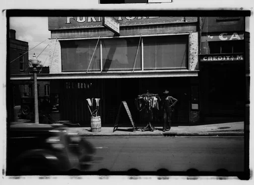 [Man with Clothesrack on Sidewalk, Natchez, Mississippi]