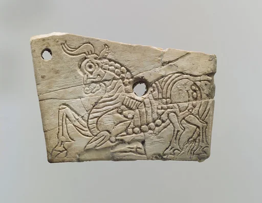 Incised furniture plaque with a kneeling bull