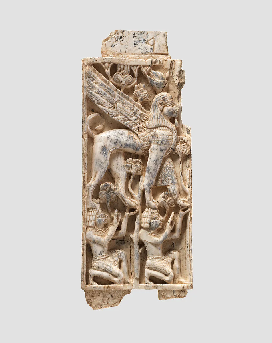 Furniture plaque carved in relief with a striding, falcon-headed winged sphinx supported by two kneeling figures — Unknown
