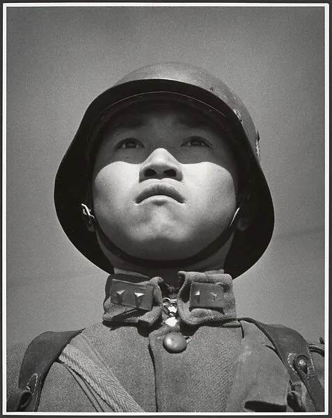 A fifteen-year-old stands at attention before his company leaves for the front and the decisive Sino-Japanese battles of the year. Hankow, March — Robert Capa