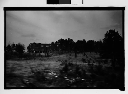 [Flat-Roofed Wooden Building, From Moving Automobile, Macon, Georgia]