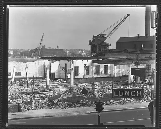 [Demolition Site with Cranes and "Lunch" Sign in Foreground, New York City]
