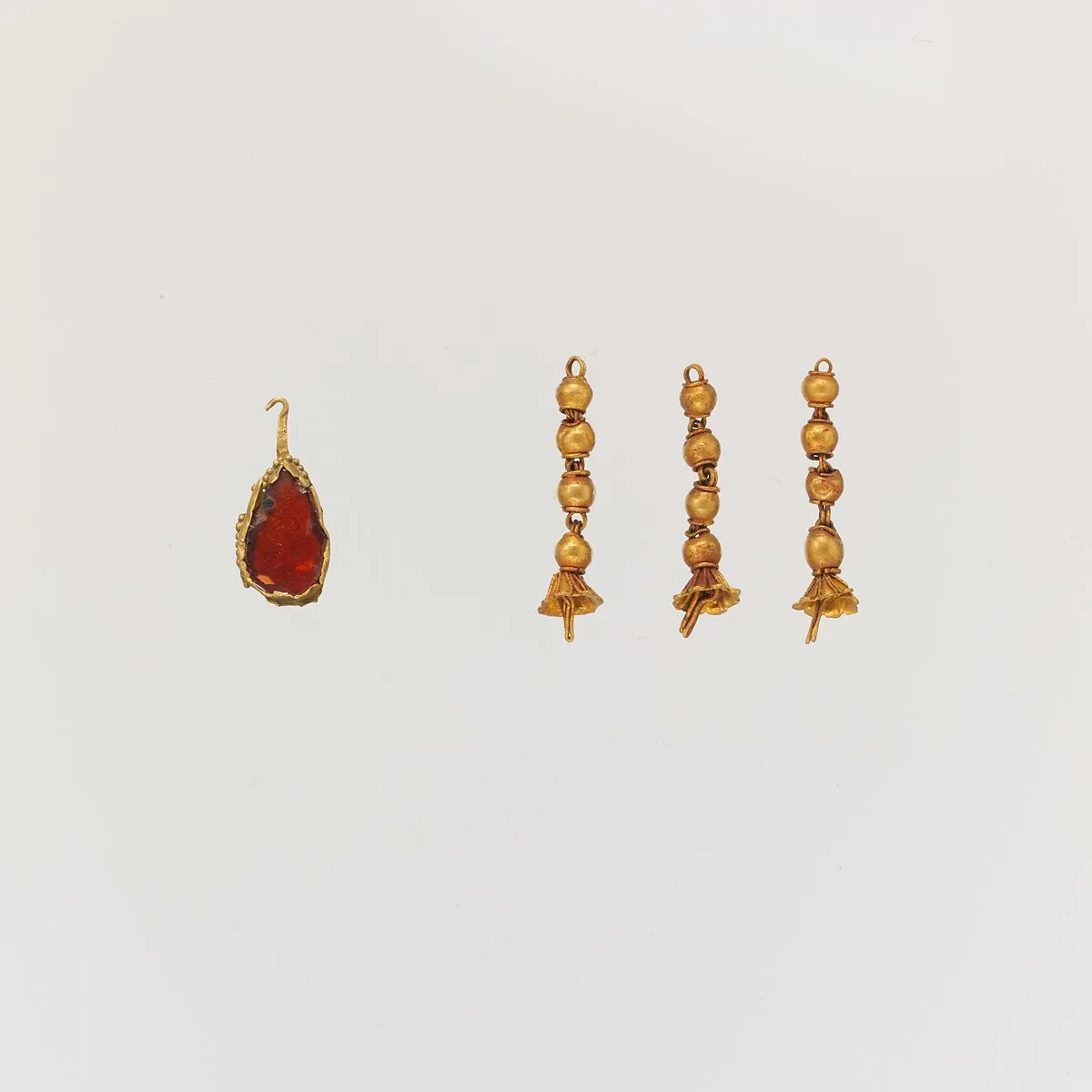 Gold pendant with garnet and three gold tassels — Unknown